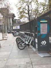 public e-bike charging station in front of Jardines del Buen Retiro park, Madrid