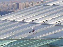 person resting on the roof of Bibliotheca Alexandrina