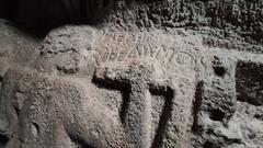 detailed view of an engraved inscription on a monument inside Nymfolipto Cave, Greece