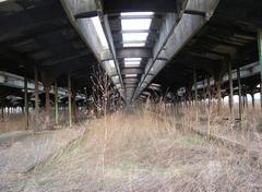 View through fence into train shed on sunny afternoon