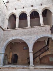 Palau dels Reis de Mallorca courtyard with gothic architecture and stone arches