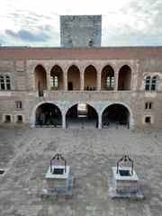 Palau dels Reis de Mallorca courtyard with well, west wing, and main tower