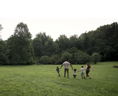 A family walking through a meadow at Gwynns Falls-Leakin Park