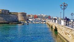 The Port of Gallipoli with boats anchored along the coastline and historic buildings in the background