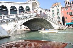 Grand Canal Rialto Bridge Venice with gondolas and tourists