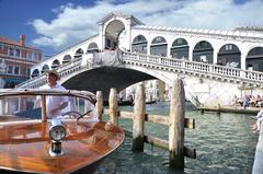 Grand Canal Venice with gondolas and tourists on Rialto Bridge