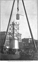 Workers lifting a large block of granite during the assembly of the Dewey Monument in San Francisco's Union Square in 1902