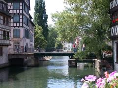 a picturesque view of Strasbourg with the river Ill, historic buildings, and a clear blue sky