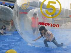 kids standing inside inflatable floating balls