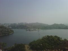 Durgam Cheruvu lake view with rocks and buildings in the background