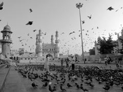 Man feeding pigeons in front of Charminar