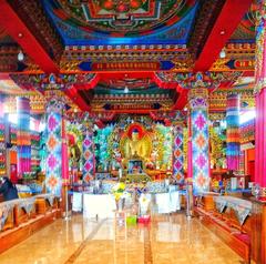 Interior view of Enchey Monastery with colorful wall murals and statues