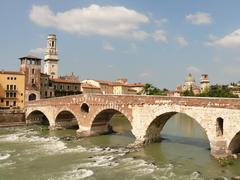 Ponte Pietra over the Adige River with watchtower and bell tower of Verona Cathedral in the background