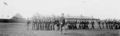 Color guard drills at the Army Relief Society garden party with Fort Jay in the background, 1908