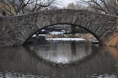 Stone bridge reflecting in water in Central Park South