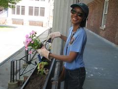 Volunteer planting flowers in a flower box at Fort Jay