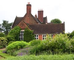 Winterbourne House in Birmingham, UK, surrounded by lush green lawns and trees