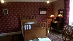 Winterbourne House bedroom with wooden bed and child's spinning wheel