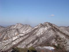 Kyeryongsan mountain range with lush green forest, a rocky peak, and clear skies