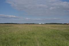 view over Panzerwiese in Munich towards Allianz Arena and Fröttmaninger Berg with wind turbine