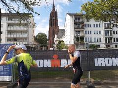 Frankfurt Cathedral tower with Ironman runners along the Main