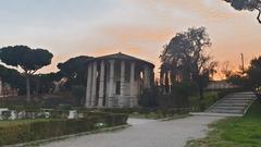 Sunset over a temple by the Tiber River with a fading orange sky