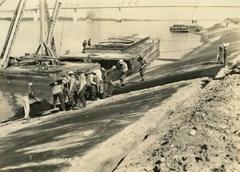 Hand paving crew at Avondale Bend Mississippi River levee in 1939, with Huey P. Long Bridge in the background.