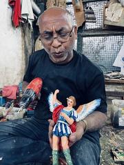 Woodworker adding finishing touches to an angel sculpture