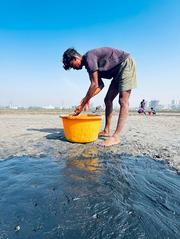 Boy preparing salt bed at Vasai salt pans