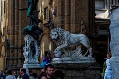 Piazza della Signoria view featuring Cellini's Medusa and Flaminio Vacca's Lion statues