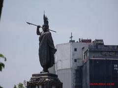 statue of Cuahutemoc against a blue sky with clouds