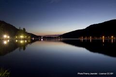 Gérardmer town illuminated at night with reflections on the lake