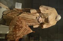 19th-century silk brocade dress and umbrella on display