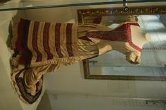 Silk brocade dress from the late 19th century and umbrella on display at the Museo del Noreste