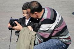 father explains camera to son outside Istanbul University