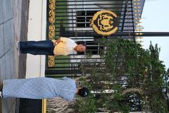 A woman photographing her husband outside Istana Negara in Malaysia