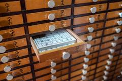 Opened drawer containing a pile of fortune papers in Sensō-Ji temple, Asakusa, Tokyo, Japan