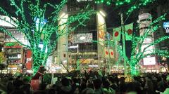 Shibuya crossing in Tokyo, Japan, bustling with pedestrians and surrounded by illuminated buildings at night