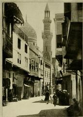 A typical street in old Cairo showing buildings with Cairo architecture, mosque with dome and minaret on the left