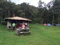 scenic camping site with tents, trees, and mountains