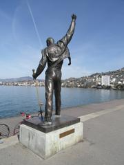 Statue of Freddie Mercury facing a lake