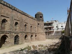 Southeast corner exterior of Khirki Mosque with Khirki village residential area in the background