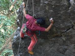 aided descent of a person on a rock face assisted by another climber