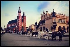 Carriages in Krakow's central market square with St. Mary's Basilica in the background