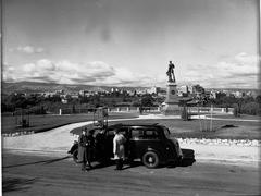 Statue of Colonel William Light on Montefiore Hill with city buildings and an automobile in the background