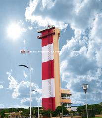 a tall white lighthouse with a blue sky background