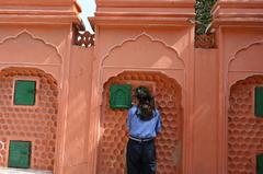 A girl looking out of a window at the Hawa Mahal in Jaipur, Rajasthan