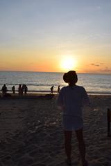 Jimbaran beach during sunset with people walking along the shore