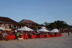 Jimbaran beach with a scenic view of the coastline, waves, and a cloudy sky