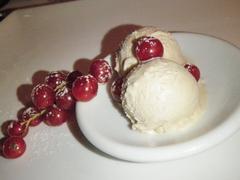 Two scoops of hazelnut ice cream with red currants